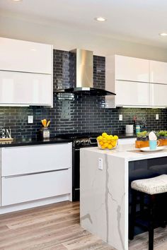 a modern kitchen with white cabinets and black counter tops, along with an island in the middle