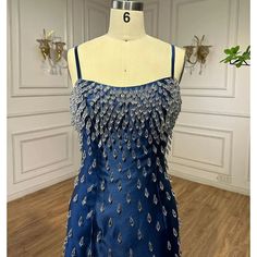 a mannequin wearing a blue dress with silver sequins on the bust