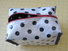 a polka dot purse sitting on top of a piece of paper next to a ruler