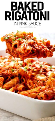 baked rigatoni in pink sauce is being lifted from a casserole dish