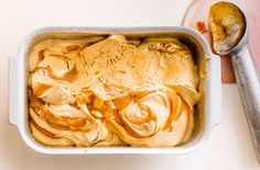 an ice cream dish with caramel swirls in it and a spoon next to it