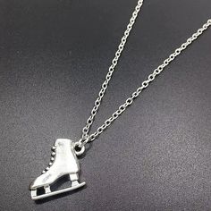 a silver necklace with a roller skate on it's back end and a chain attached to