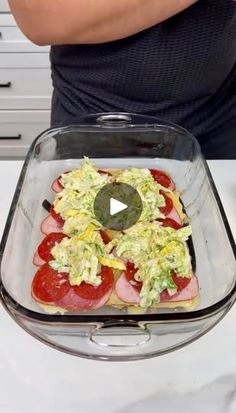 a person standing in front of a glass dish with food on it and the video is being viewed