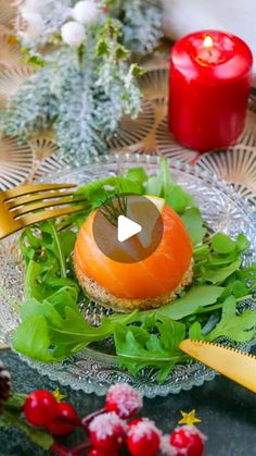 a glass plate topped with food next to a knife and fork on top of a table