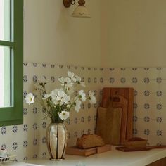 a vase filled with white flowers sitting on top of a counter next to a cutting board