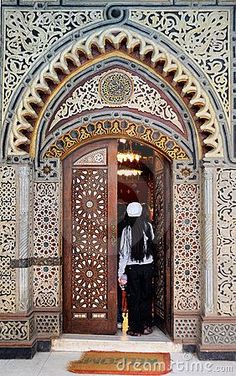 a man standing in front of an ornate doorway