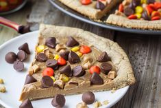 a piece of chocolate peanut butter pie on a white plate with candy candies around it