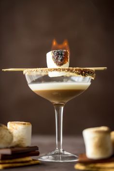 a martini glass filled with liquid and marshmallows