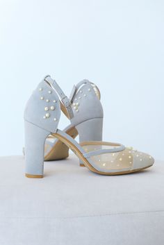 a pair of white shoes with pearls on the heel and heels are sitting on top of a