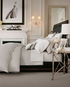 a bedroom with white bedding and chandelier