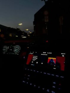 the dashboard of a car at night with city lights in the background