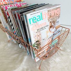 a magazine rack filled with magazines on top of a white rug