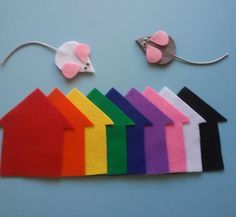 felt houses and mouses are arranged on a blue background with the colors of the rainbow