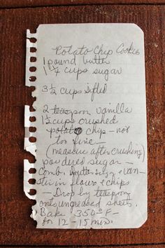 a piece of paper with writing on it sitting on top of a wooden table next to a knife