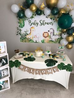 a baby shower is set up with balloons and jungle themed decorations, including a welcome sign