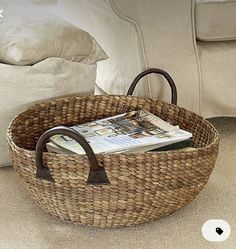 a wicker basket sitting on the floor next to a couch