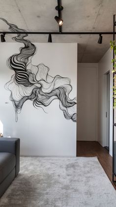 a living room with a couch and large wall mural on the wall in front of it