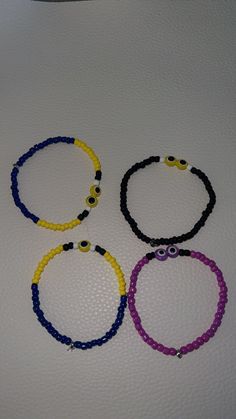 four bracelets with beads are sitting on a table