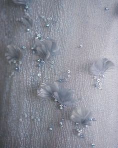 the fabric has flowers on it and is very delicately detailed with beaded sequins