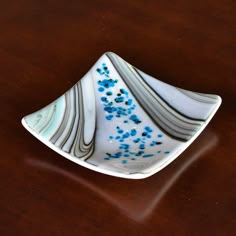 a white and blue plate sitting on top of a wooden table