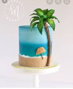 there is a blue cake with a palm tree on the top and sand underneath it