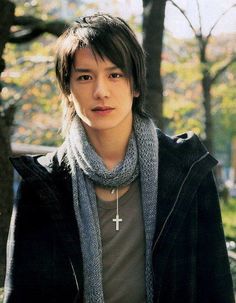 a young man wearing a cross necklace and scarf