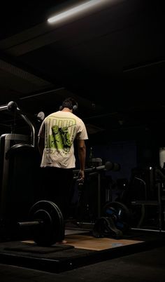 a man standing next to a barbell in a gym