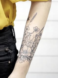 a woman's arm with flowers on it and a zipper in the back pocket