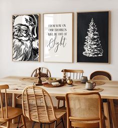 a dining room table with chairs and pictures on the wall above it, along with two christmas trees