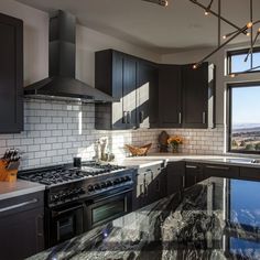 a kitchen with marble counter tops and stainless steel appliances, along with dark wood cabinets