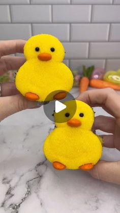 two small yellow chicks sitting on top of a counter