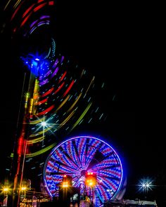 the ferris wheel is lit up at night