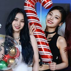 two girls are holding up giant candy canes