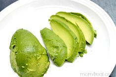 two pieces of avocado on a white plate