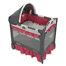 a baby crib that is red and grey with a pink bed skirt on it