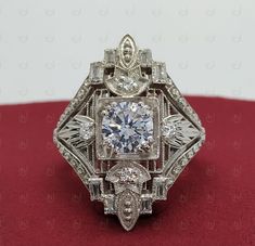 an antique diamond ring is displayed on a red surface