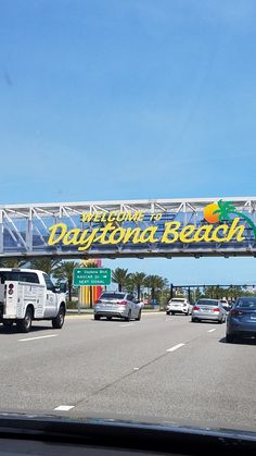 cars are driving on the highway under a sign that says daytona beach in front of them