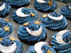 cupcakes decorated with blue icing and gold stars, moon and crescent decorations