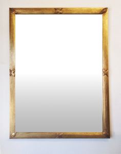 a gold framed mirror hanging on the wall