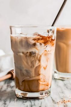 two glasses filled with ice cream on top of a marble counter next to each other