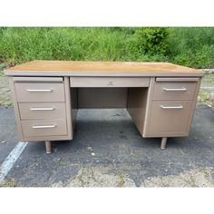 an office desk with two drawers in the middle and one drawer on each side, sitting in a parking lot