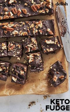 a cutting board topped with brownies covered in nuts