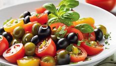 a white bowl filled with olives and tomatoes