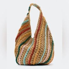 a crocheted bag with multicolored stripes on the front and bottom, sitting upright