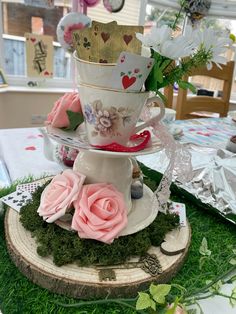 three tiered teacups are stacked on top of each other with pink roses