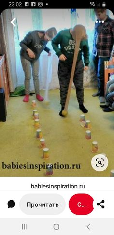 two people are playing with cups in the living room and one person is holding a stick