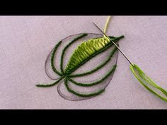 a close up of a piece of cloth with some green thread on top of it