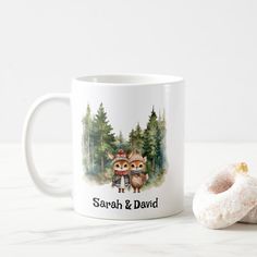 a coffee mug with two owls on it next to a donut