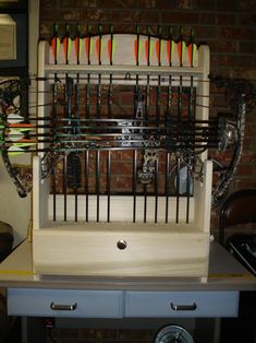 a bird cage with many different types of birds in it on a desk next to a brick wall