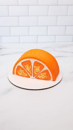 an orange cut in half sitting on top of a white plate